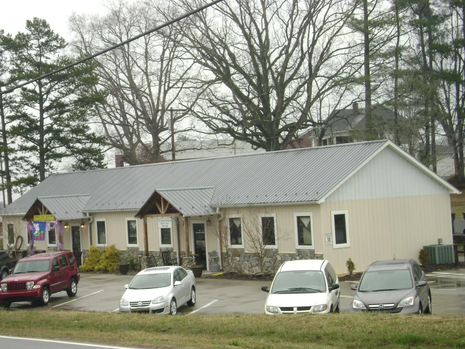 Gray metal roof with timber entry brackets on a small commercial building in Lehigh
